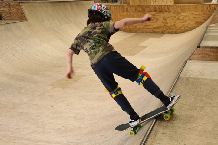 Skateboarder going down ramp on indoor skatepark
