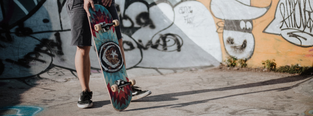 man holding a skateboard in skate park