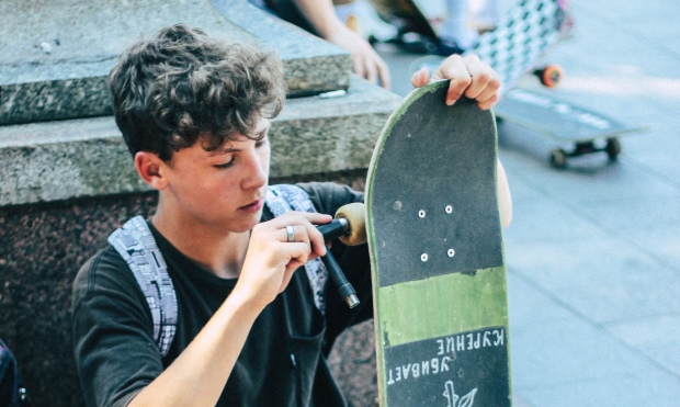 Boy fixing his skateboard wheel showing great creative problem solving